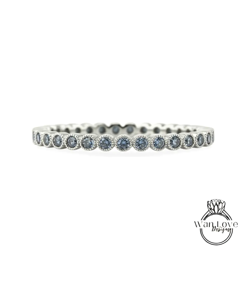 A silver band ring with blue gemstones set in a row.