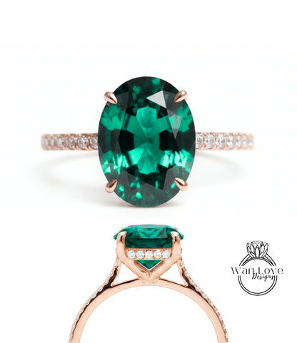 a large oval-shaped green gemstone ring with a gold band and small diamonds.