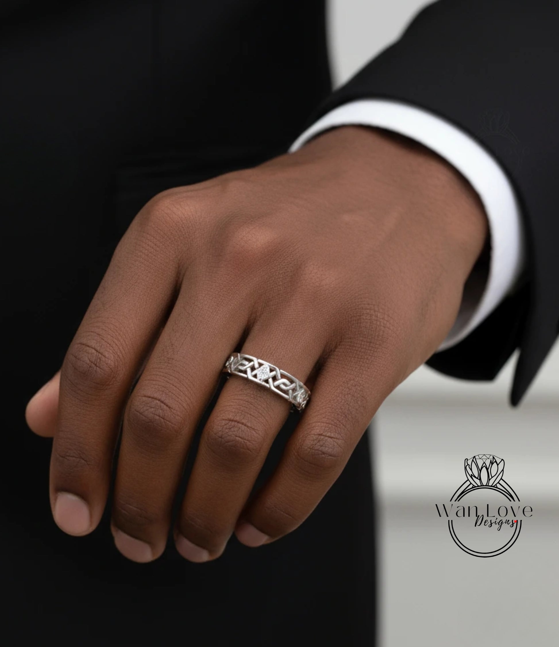 A close-up of a person's hand wearing a silver ring on the ring finger.