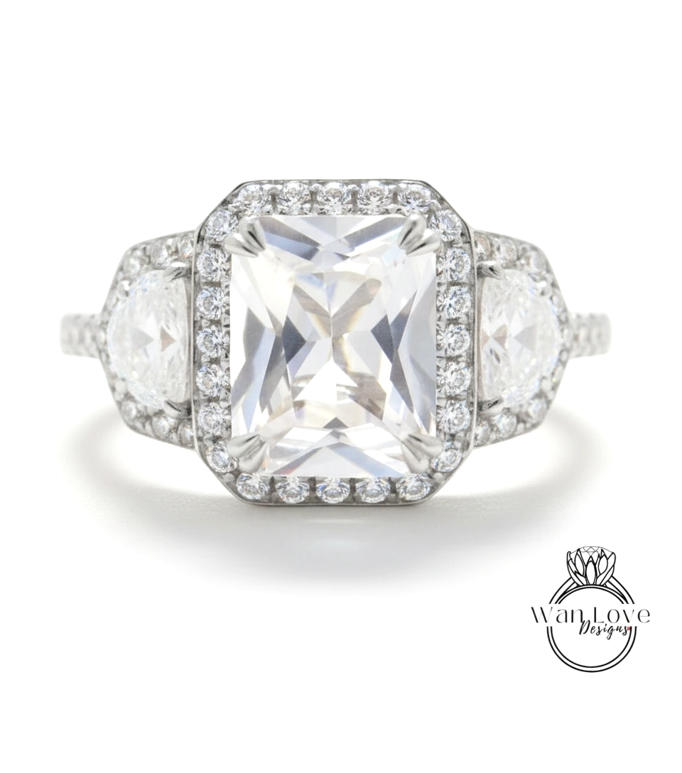 A stunning diamond engagement ring with a large central diamond surrounded by smaller diamonds on either side, set in a halo of smaller diamonds.