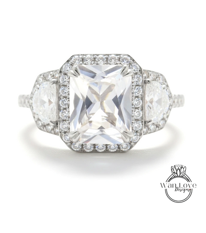 A stunning diamond engagement ring with a large central diamond surrounded by smaller diamonds on either side, set in a halo of smaller diamonds.