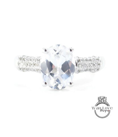 A close-up view of a diamond engagement ring with a large oval-shaped gemstone set in a silver band.