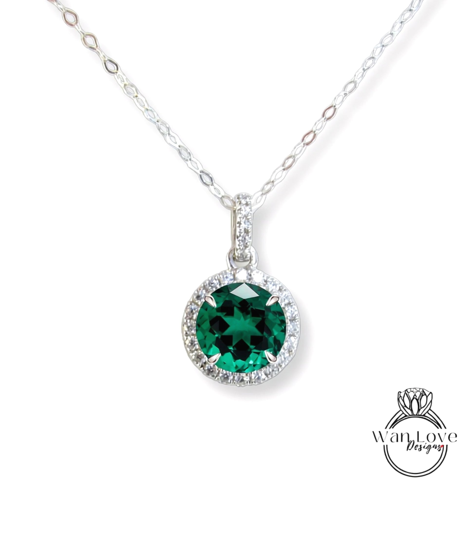 A silver necklace with a large, green gemstone pendant.