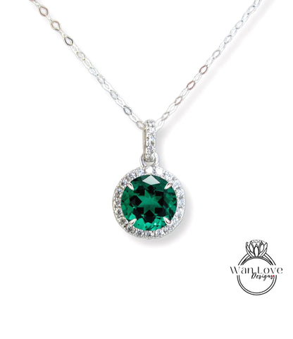 A silver necklace with a large, green gemstone pendant.