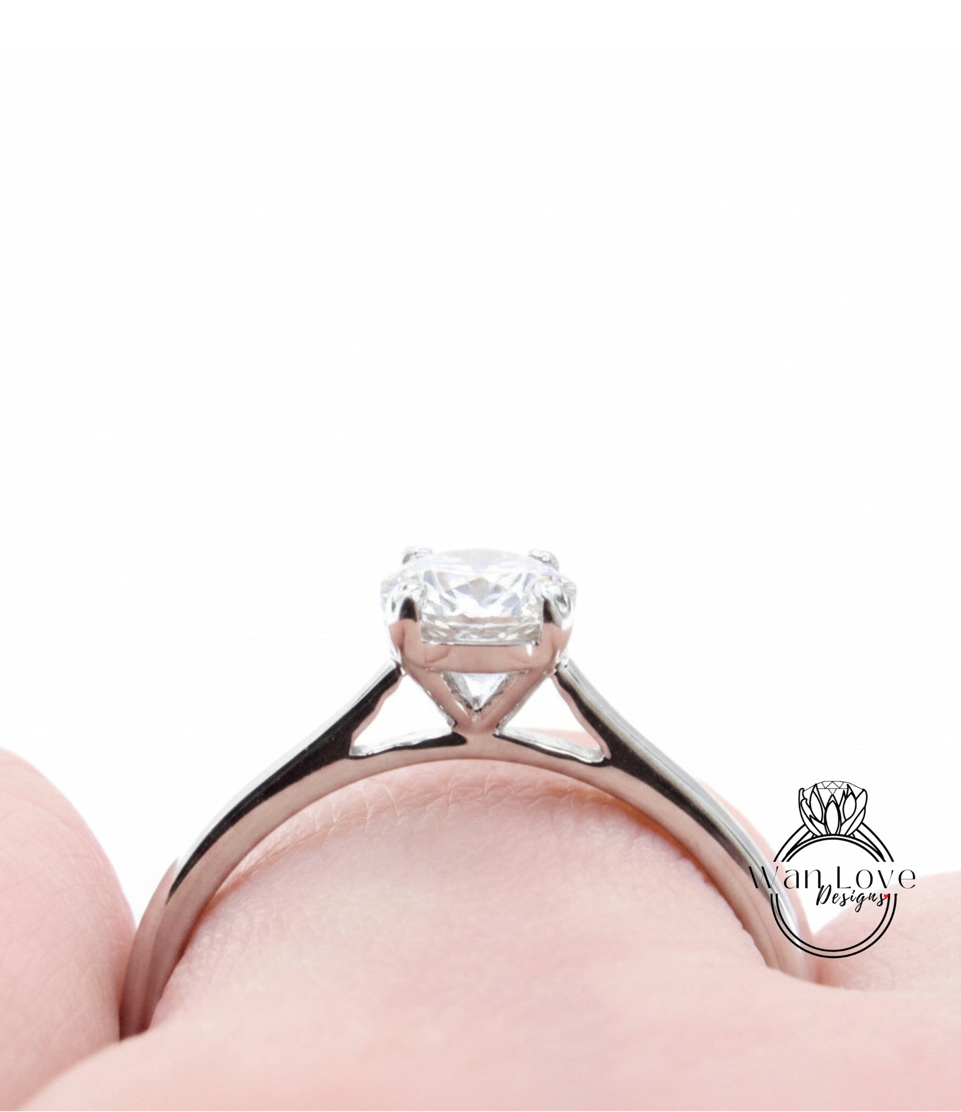 A close-up view of a diamond engagement ring on a person's finger.