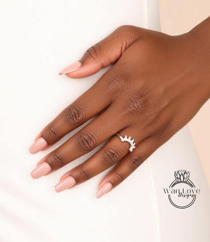 A close-up of a hand wearing a ring with a decorative design.