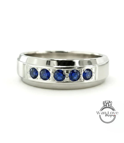 A silver ring with a row of blue sapphires set in the band.