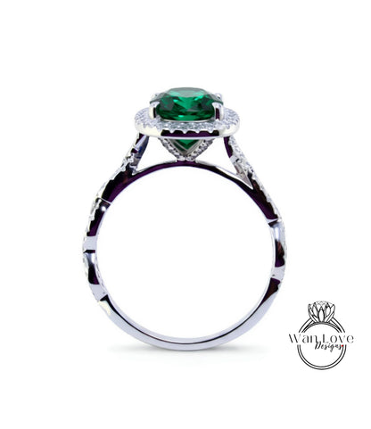 A silver ring with a large, green gemstone at the center, surrounded by smaller diamonds.