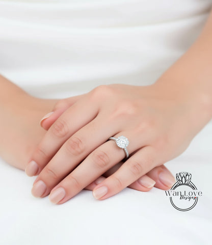 A close-up of a person's hand wearing a diamond engagement ring.