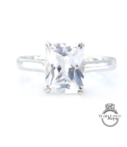 A close-up view of a diamond engagement ring with a large, clear gemstone set in a silver band.