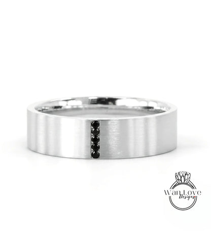 A silver-colored ring with a vertical black gemstone in the center.