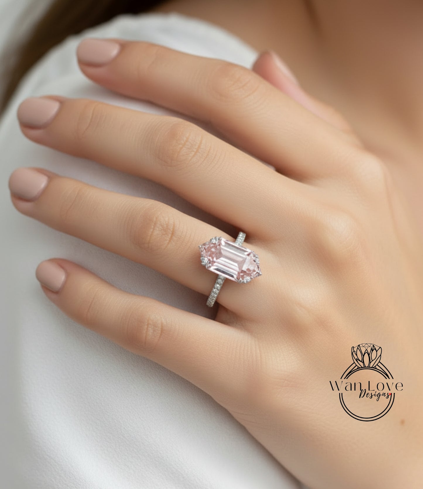 A close-up of a person's hand wearing a large, pink diamond engagement ring.