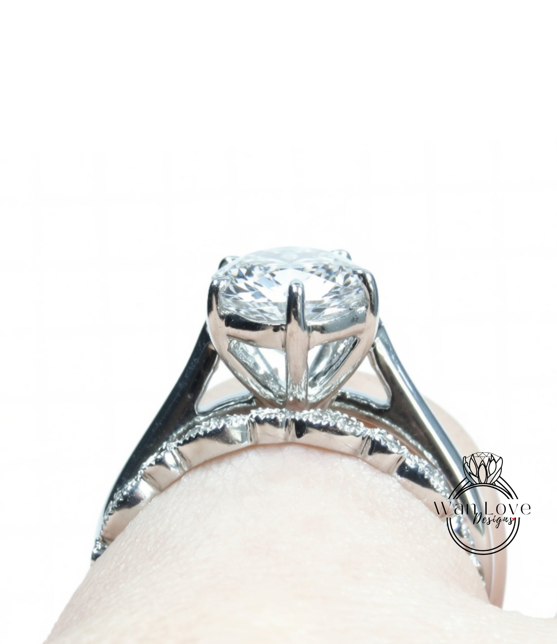 A close-up view of a diamond engagement ring on a person's hand, showcasing the intricate design and sparkling gemstone.