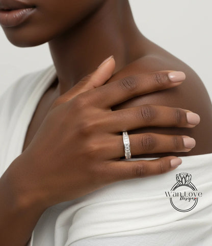 A close-up of a person's hand wearing a diamond ring, with their fingers gently resting on their shoulder.
