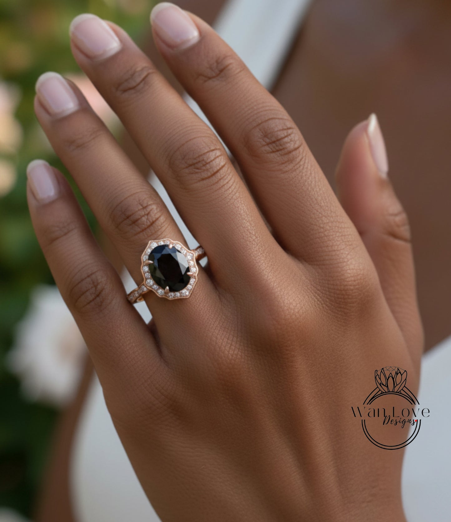 A close-up of a person's hand wearing a gold ring with a large black gemstone, likely a diamond.