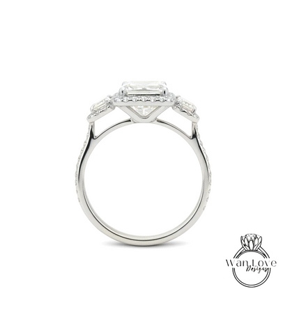 A silver engagement ring with a large central diamond surrounded by smaller diamonds on either side.