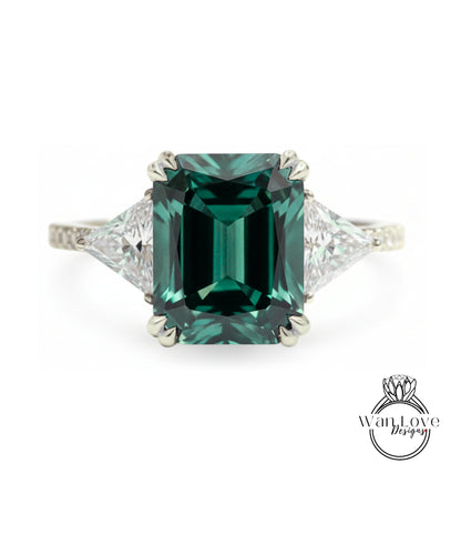 A large, green gemstone engagement ring with a diamond-encrusted band.