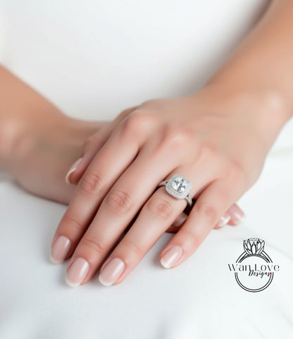 A close-up of a hand wearing a diamond ring, resting on a white surface.