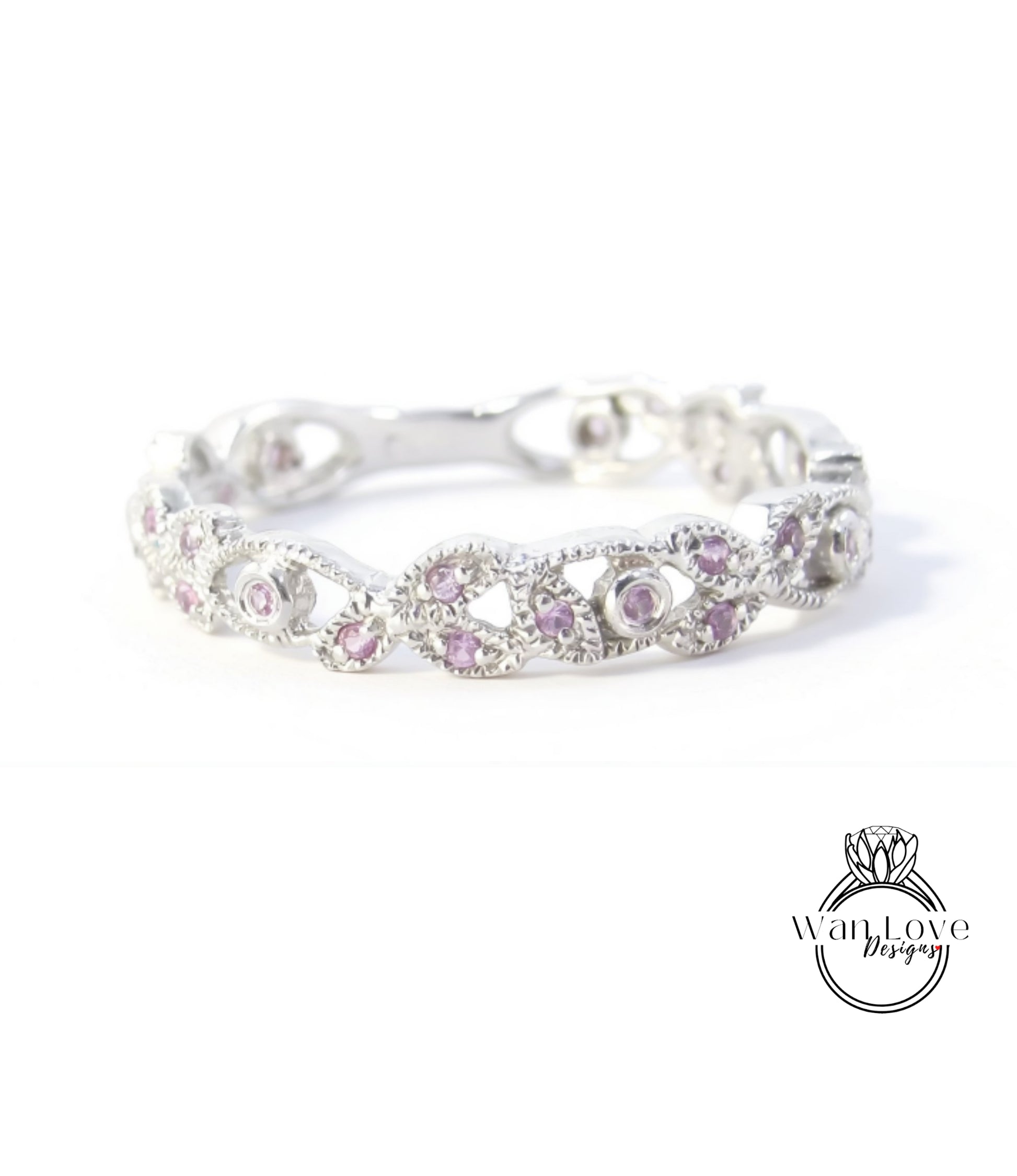 A silver ring with a decorative band adorned with small, round, purple gemstones.