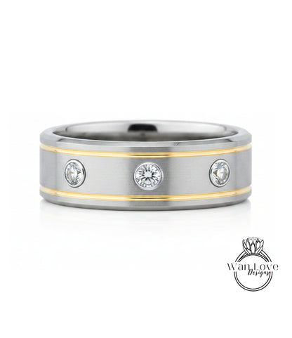 A silver and gold ring with three round diamonds set in the center.