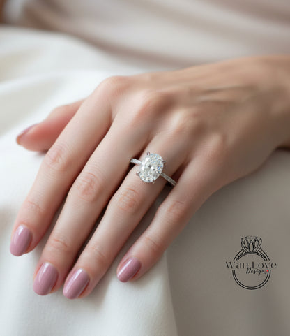A close-up of a person's hand wearing a large diamond engagement ring.