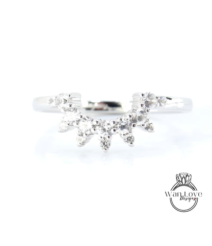 A silver ring with a large, sparkling diamond in the center, surrounded by smaller diamonds.