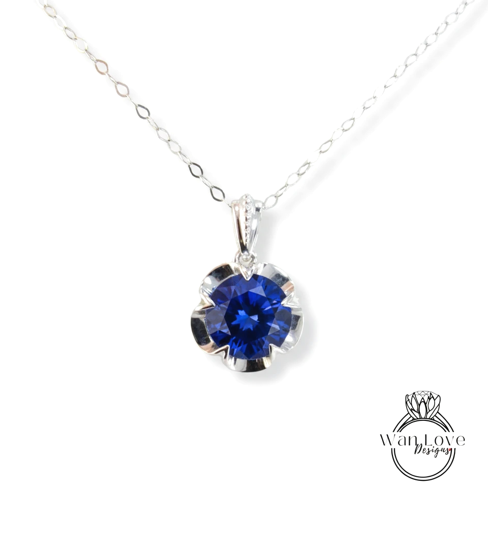 A silver necklace with a large blue gemstone pendant.
