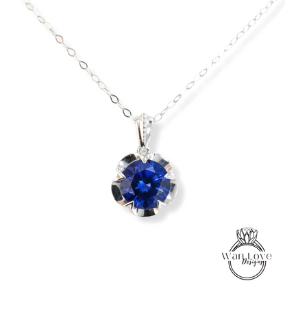 A silver necklace with a large blue gemstone pendant.