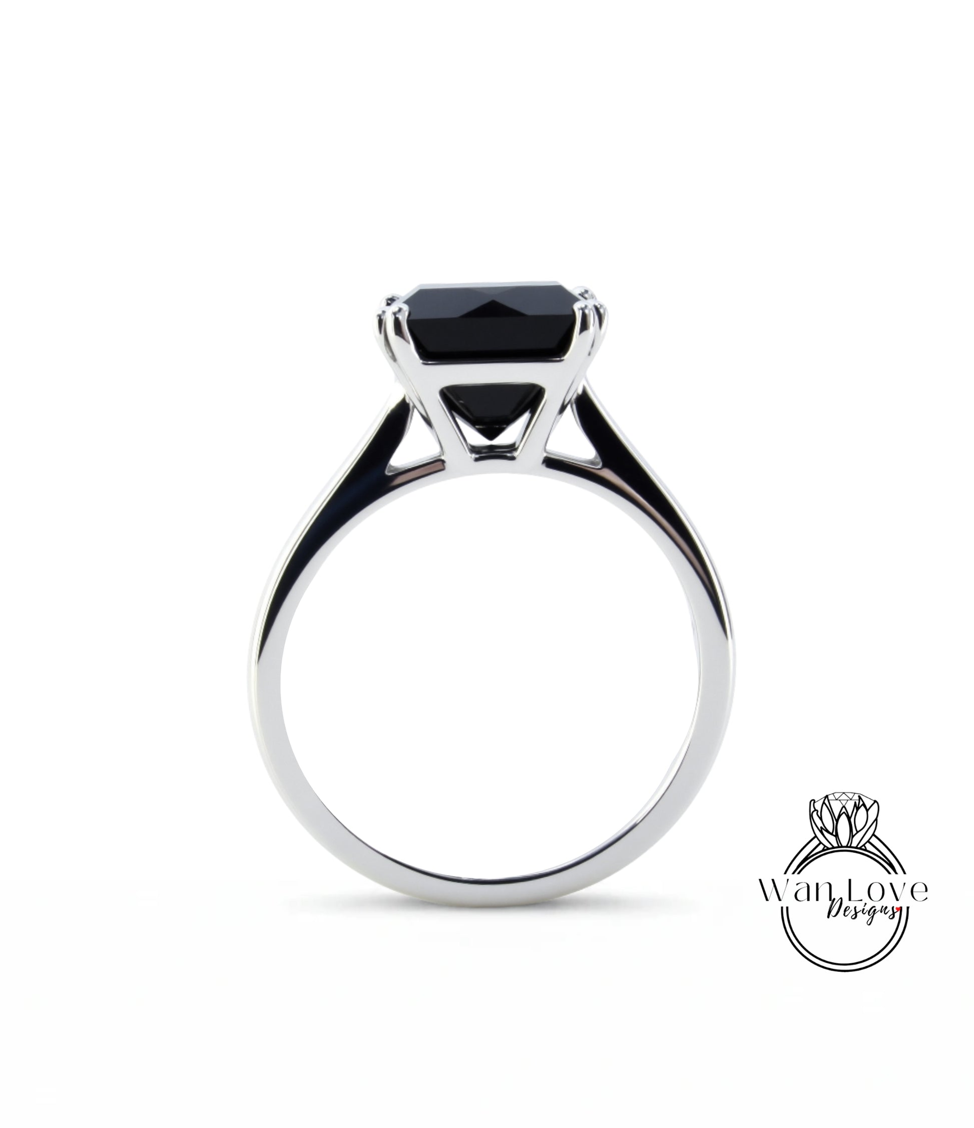 A silver ring with a large black gemstone, likely a diamond, set in the center.