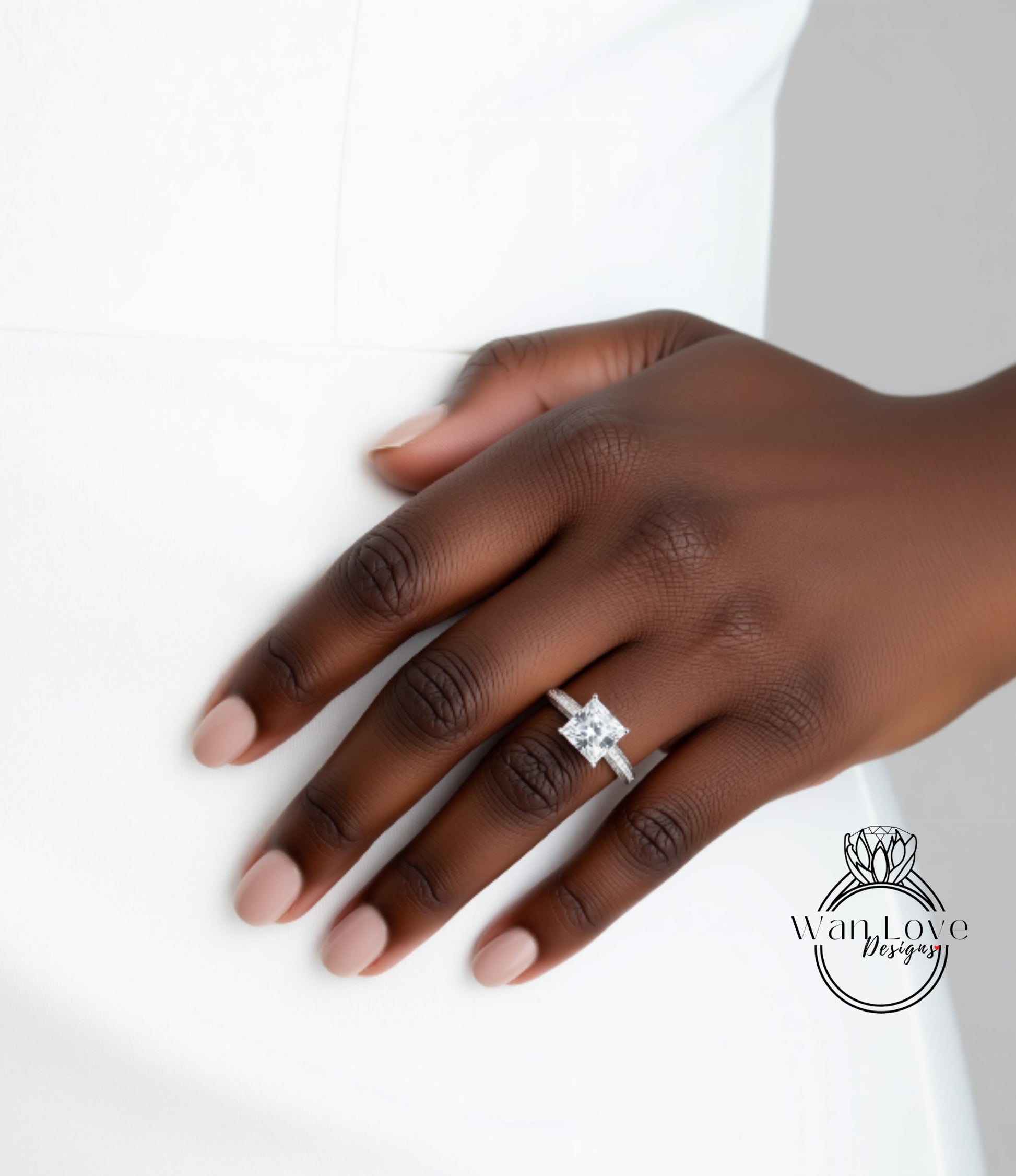 A close-up of a hand wearing a diamond engagement ring.