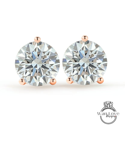 A pair of elegant earrings with large, brilliant-cut diamonds set in a rose gold-colored metal.