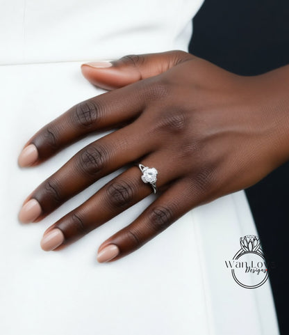 A close-up of a hand wearing a diamond engagement ring.