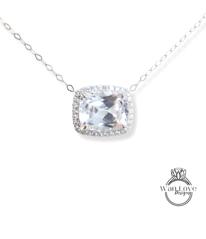 A necklace with a large, clear gemstone pendant, surrounded by a halo of smaller diamonds.