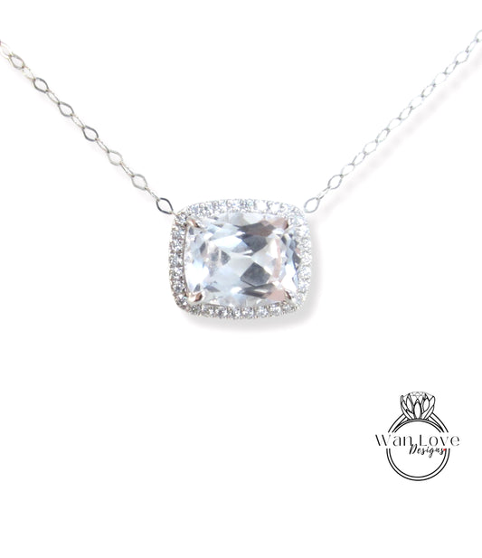 A necklace with a large, clear gemstone pendant, surrounded by a halo of smaller diamonds.