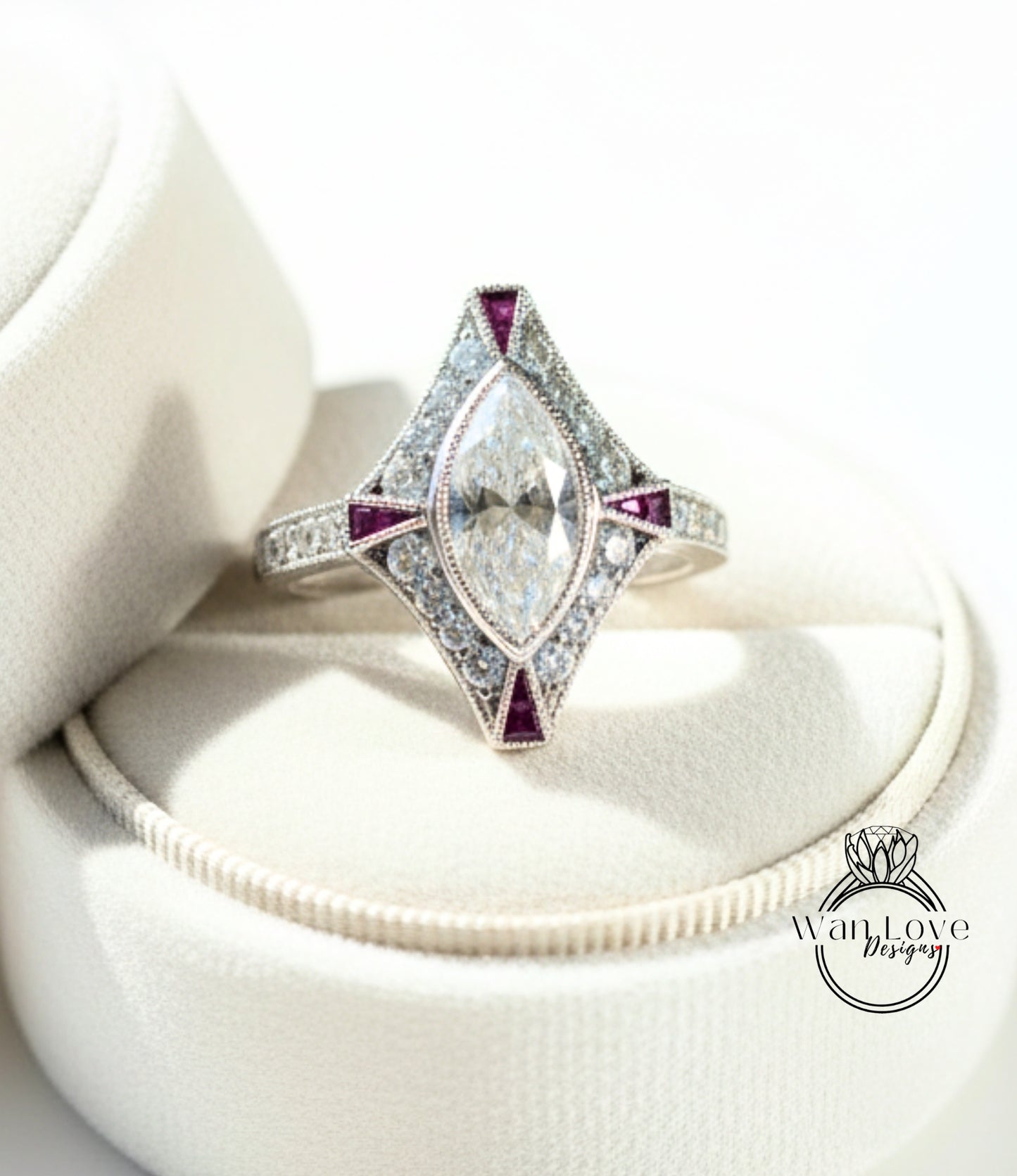 A diamond engagement ring with a large central diamond surrounded by smaller diamonds and colored gemstones, displayed on a white velvet background.