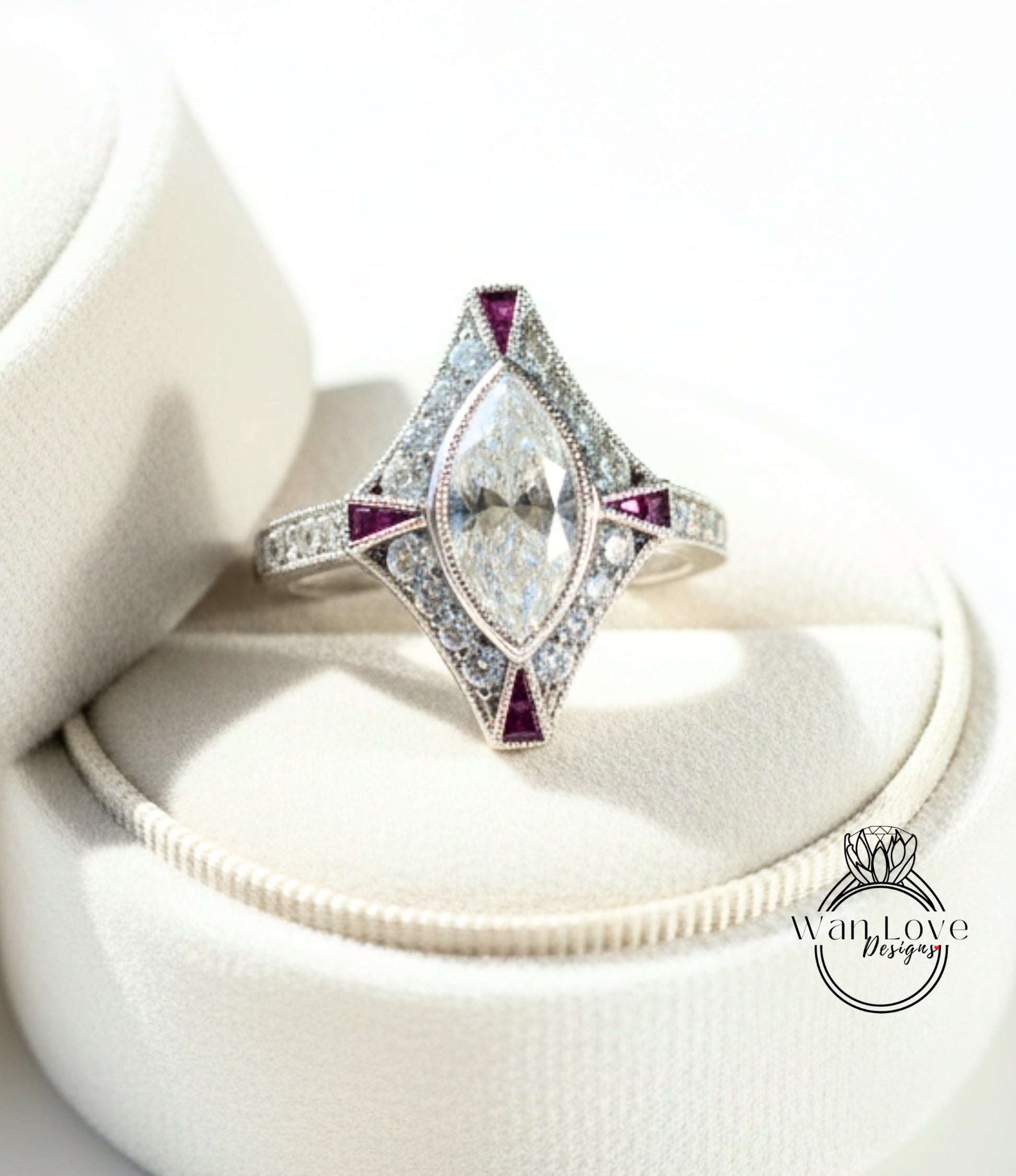 A diamond engagement ring with a large central diamond surrounded by smaller diamonds and colored gemstones, displayed on a white velvet background.