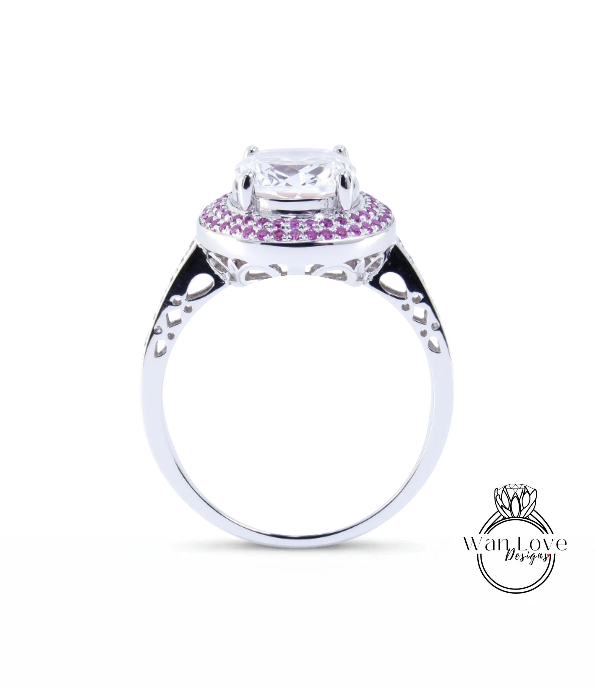 A silver ring with a large central gemstone surrounded by smaller gemstones, and a decorative band with a floral pattern.