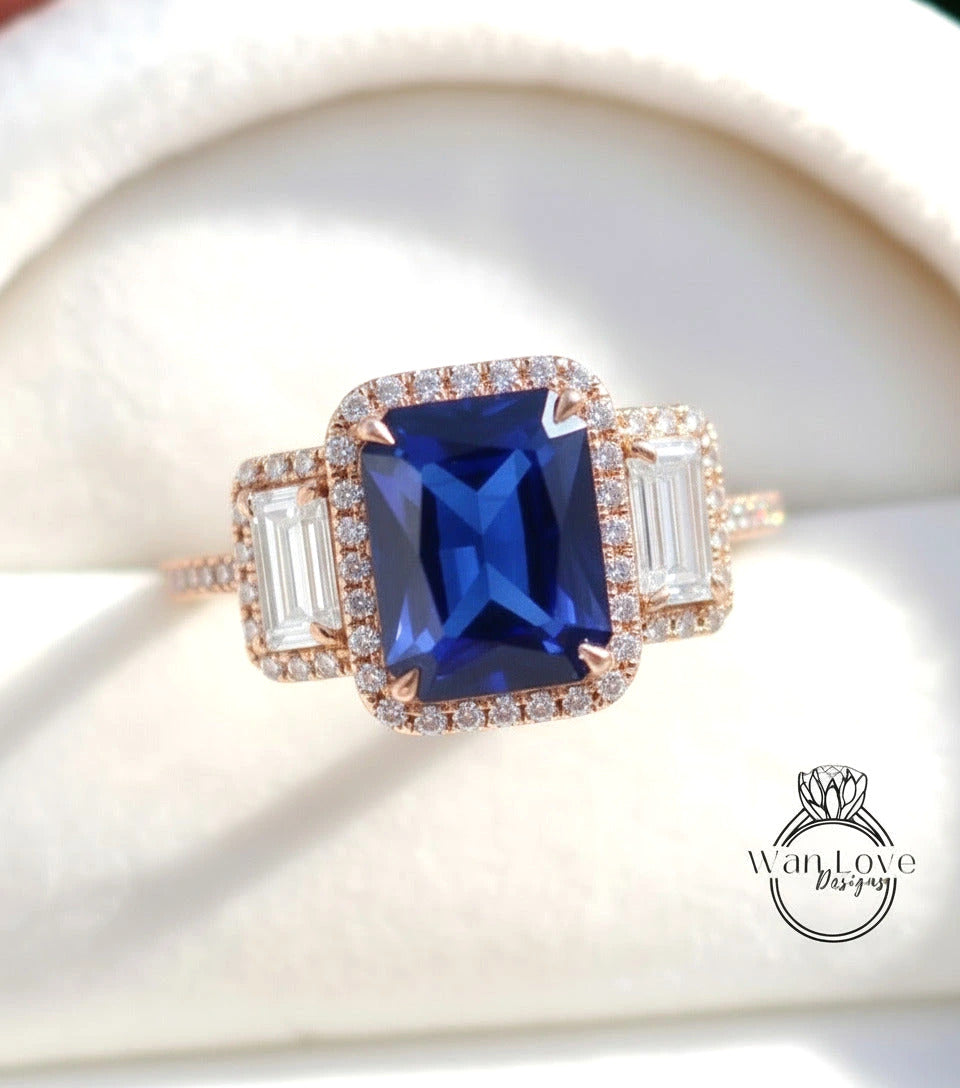A close-up image of a beautiful blue gemstone ring with a large central blue gemstone surrounded by smaller diamonds and a halo of smaller diamonds around the edges.