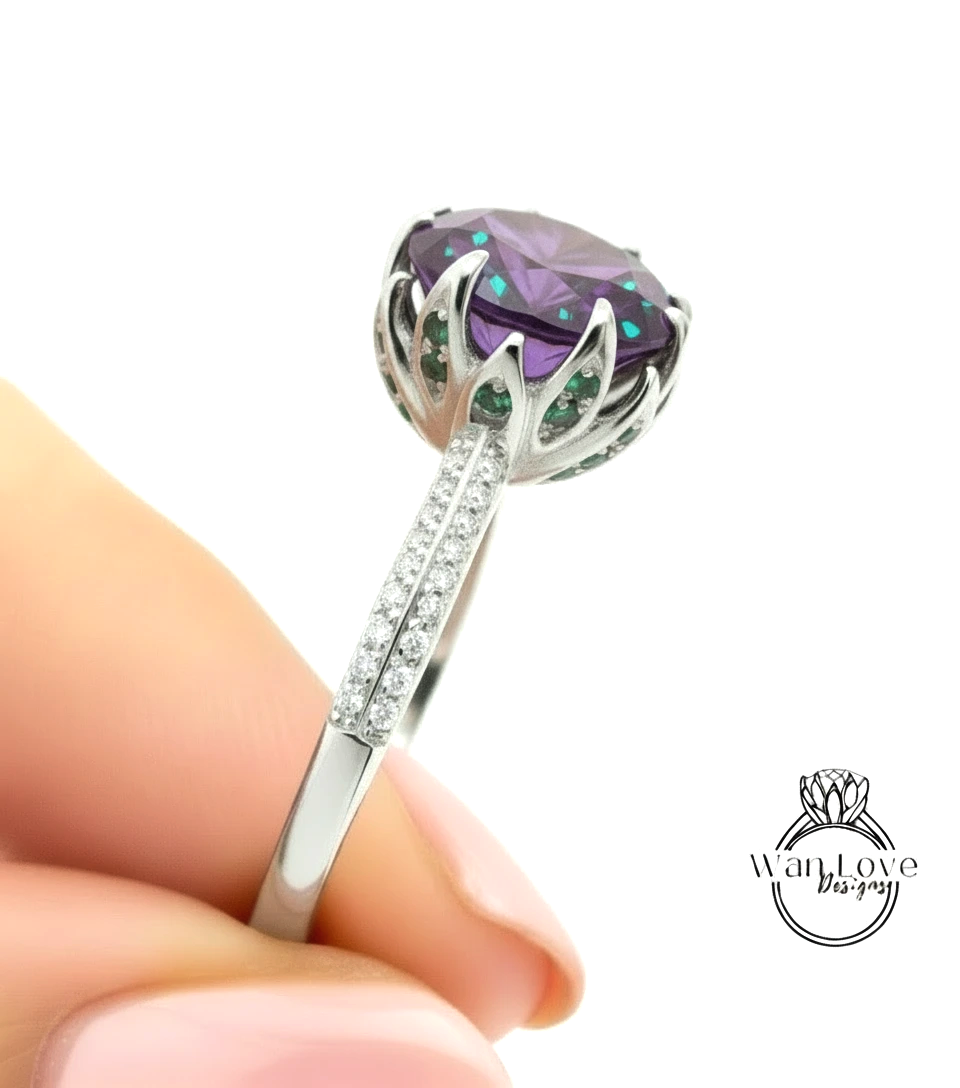 A close-up image of a person's hand holding a silver ring with a large purple gemstone, likely an amethyst, and a diamond accent.