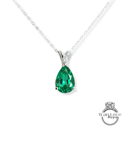 A silver necklace with a large, green gemstone pendant.