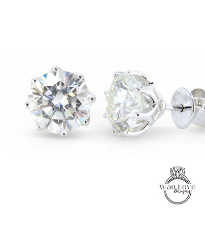 A pair of elegant diamond earrings with a large, brilliant-cut diamond set in a silver metal frame.