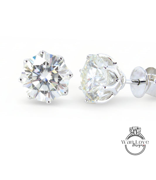 A pair of elegant diamond earrings with a large, brilliant-cut diamond set in a silver metal frame.