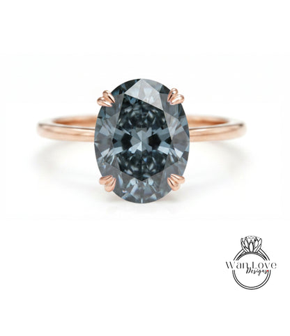 A close-up of a rose gold ring with a large, dark blue diamond as the centerpiece.