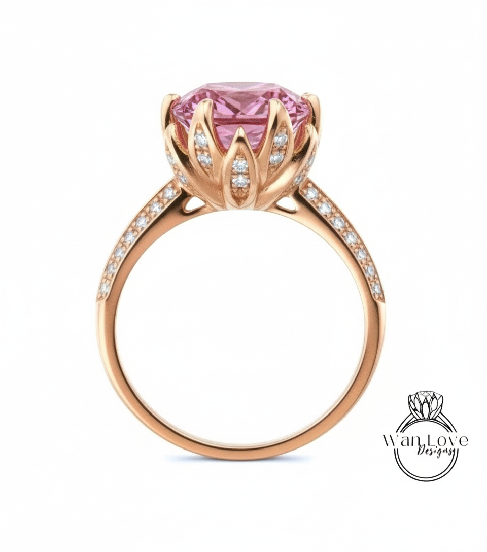 A gold ring with a large pink gemstone, likely a pink diamond, set in a decorative flower-like design.