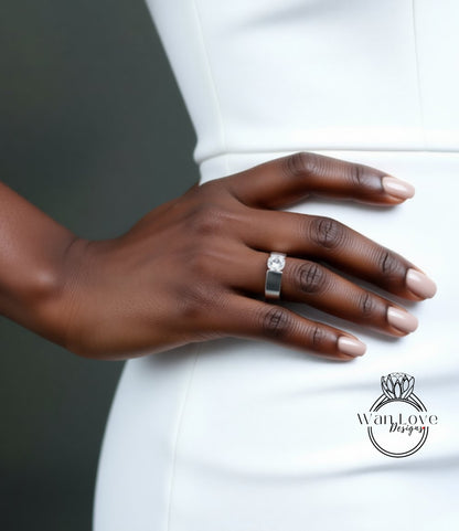 A close-up of a person's hand wearing a ring, with a white dress visible in the background.