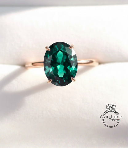 A gold ring with a large oval-shaped green gemstone, which appears to be a sapphire.