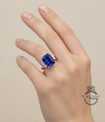 A close-up of a hand wearing a large blue gemstone ring with a gold band.