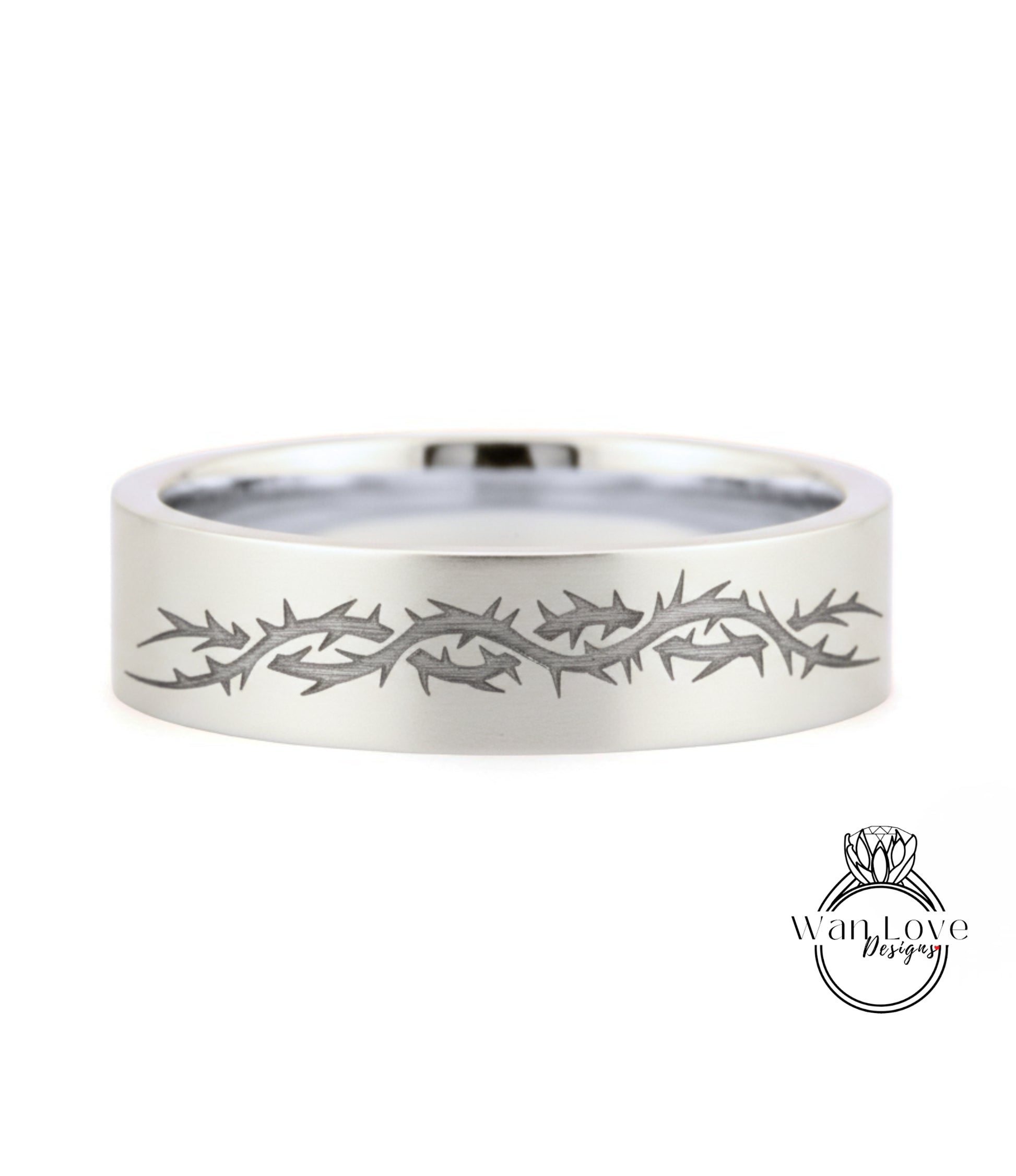 A silver ring with a design of thorns or spikes along its edge.