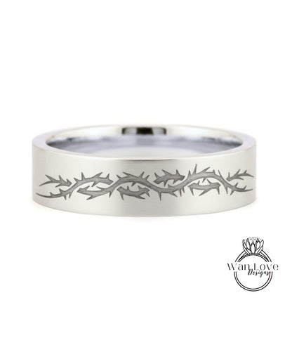 A silver ring with a design of thorns or spikes along its edge.