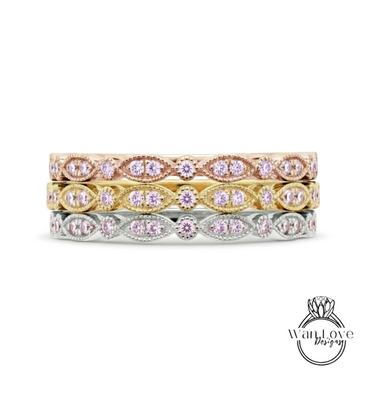 A stack of three rings with pink gemstones set in a decorative pattern.